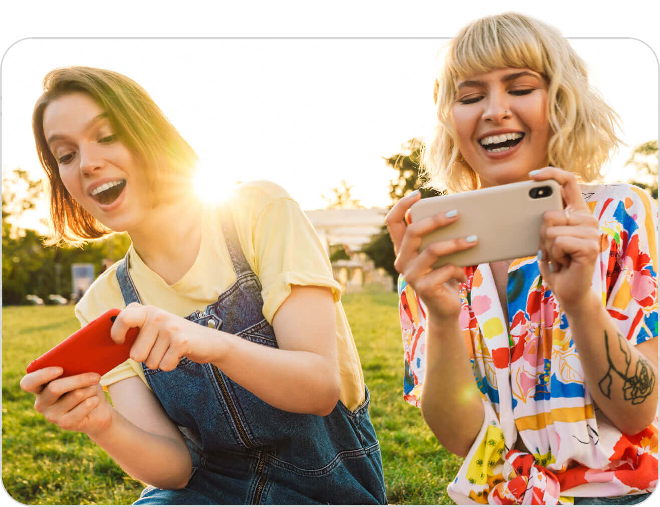 Two women laughing and playing a mobile game together