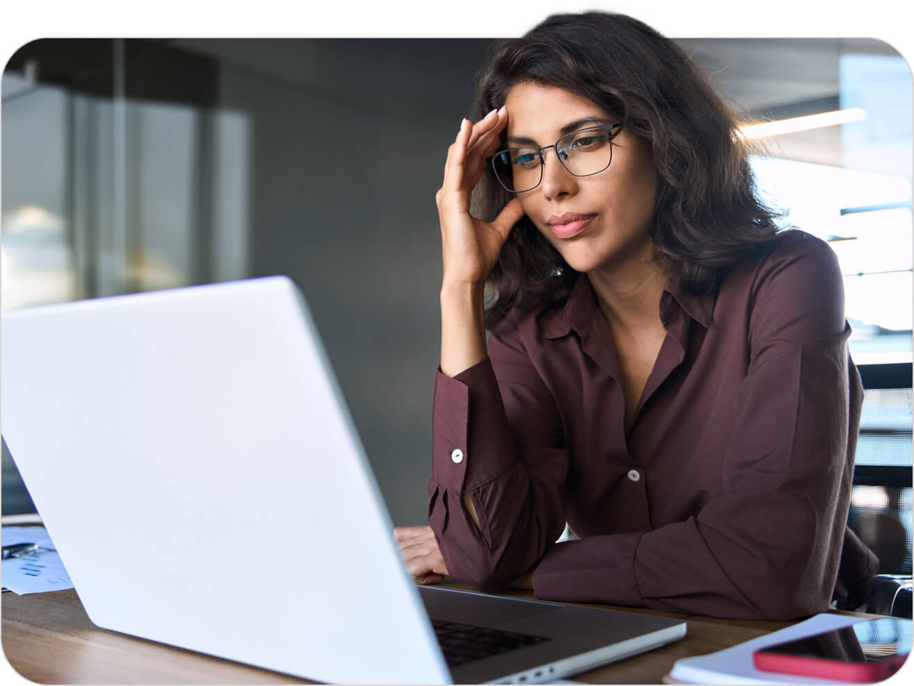 Woman sitting at desk and looking at laptop screen