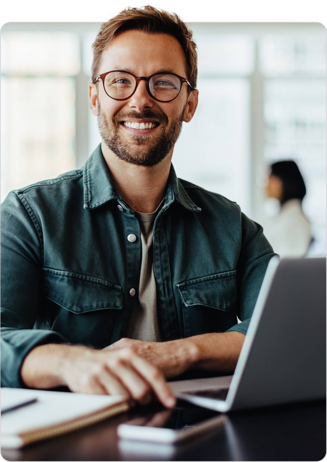 Man with laptop smiling at the camera